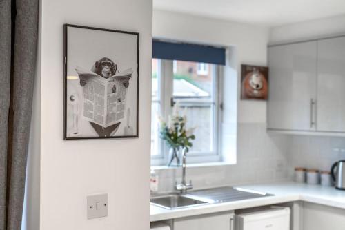 a kitchen with a picture of a newspaper on the wall at Luxury 5 Bed House - Free Parking - Perfect For Contractors & Families in Welwyn Garden City