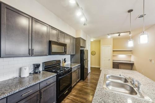 a kitchen with stainless steel appliances and a sink at Cullen 4307 I Parking I Pool I Gym I 2bd2bth in Houston