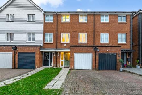a large brick house with two garages at Luxury 5 Bed House - Free Parking - Perfect For Contractors & Families in Welwyn Garden City