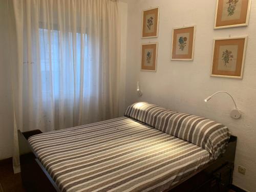 a bed in a room with a window and a lamp at Villino a 300 mt dal mare - A solo un'ora di treno dal centro di Roma in Anzio