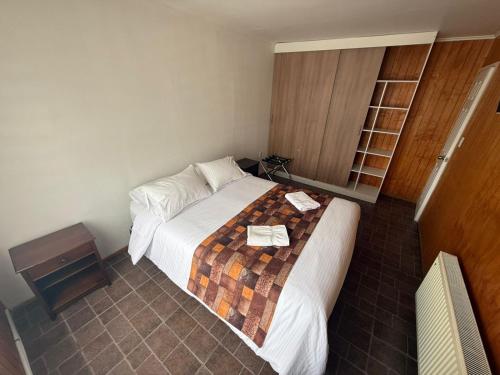 a hotel room with a bed and a night stand at Cabañas Última Esperanza in Puerto Natales
