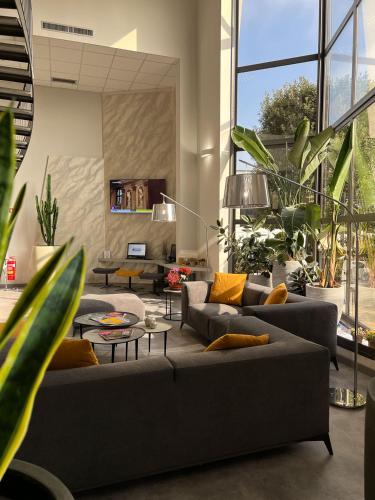 Ospedaletto LodigianoにあるBreak Hotelのリビングルーム(ソファ、鉢植えの植物付)