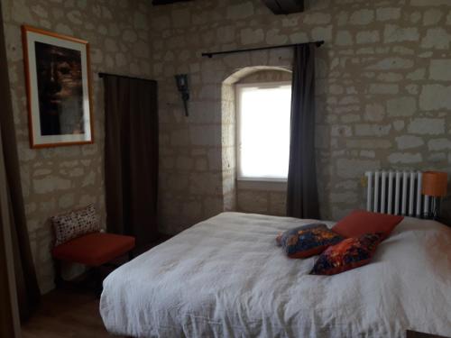 une chambre avec un lit avec deux oreillers dessus dans l'établissement Le jardin des envies, à Candes-Saint-Martin