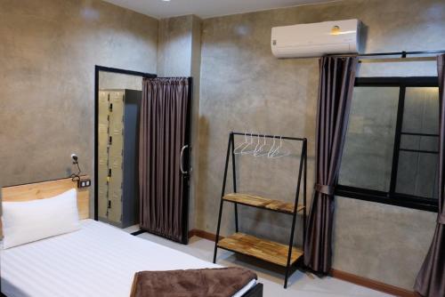 a bedroom with a bed and a air conditioner at Yaowarate Sport Club and Resort ไร่เยาวเรศ in Ban Mae Ho Phra