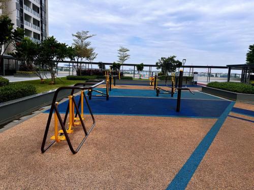 a park with a playground with yellow swings at TheBess Hotel Tokyo is located adjacent to Singapore and offers a sea viewIt is a family business smart room with the sea view of Princess Bay富力公主湾 in Johor Bahru