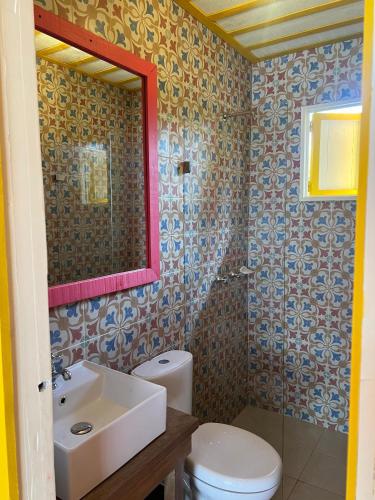 a bathroom with a sink and a toilet and a mirror at El Agrado Restaurante Cabañas in Líbano