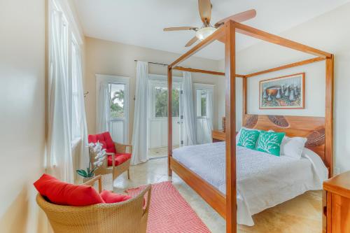 a bedroom with a canopy bed and a chair at Blue Hawaii House in Princeville