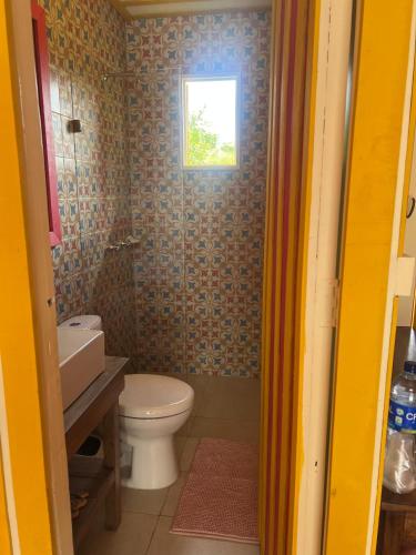 a bathroom with a toilet and a window at El Agrado Restaurante Cabañas in Líbano