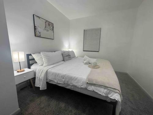 a white bedroom with a bed with a nightstand and a bed sidx sidx sidx at Affordable Stay Near Proctors A8 in Schenectady