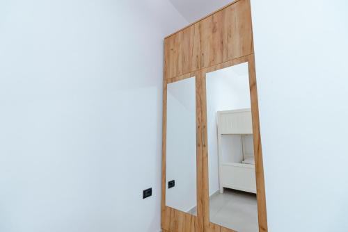 a mirror in a room with a white wall at Kotarja Apartments in Dhërmi