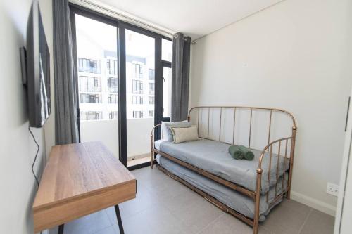 a room with a bed and a table and a window at Infinite Tide Bellamare in Summerstrand