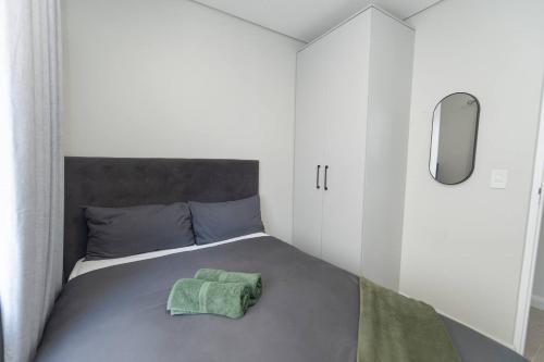 a bedroom with a bed with a green towel on it at Infinite Tide Bellamare in Summerstrand