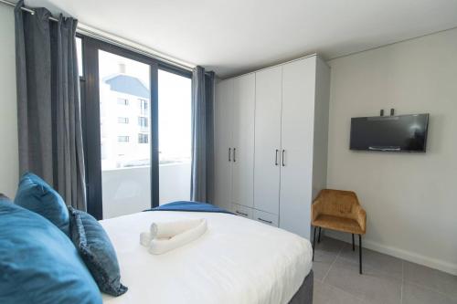 a bedroom with a bed with a tv and a window at Infinite Tide Bellamare in Summerstrand