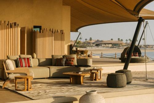 a living room with a couch and some tables at Our Habitas Ras Abrouq in Dukhān