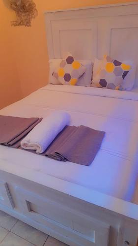 a white bed with towels and pillows on it at Villa Serene Hotel in Kitale