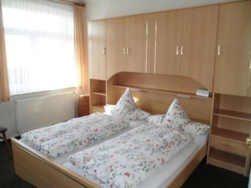 a bedroom with two beds and a large window at Unterm-Reetdach-Whg-4-unten-rechts in Borkum