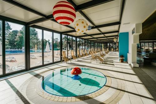 a swimming pool with a large room with windows at House Banovci with private Sauna in Banovci