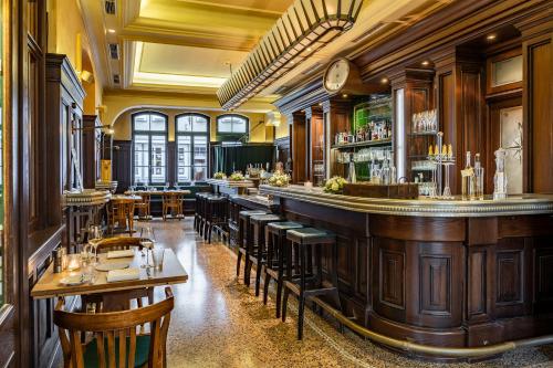 a restaurant with a bar and some tables and chairs at Hotel Alma Am Anger in Erfurt