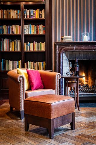 a living room with a couch and a chair and a fireplace at Hotel Alma Am Anger in Erfurt