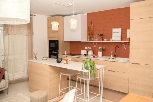 une cuisine avec des armoires en bois et un comptoir blanc dans l'établissement Superbe T4 vue mer et etang, terrasse et parking, à Sète