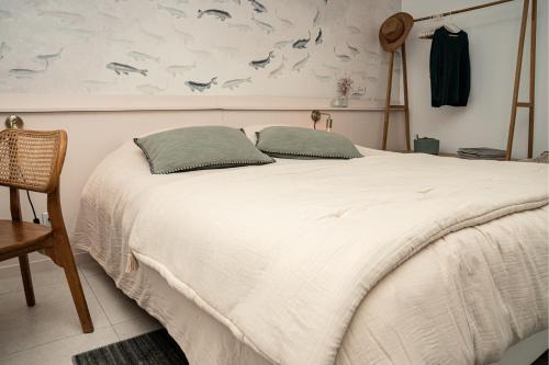 une chambre avec un lit avec deux oreillers dessus dans l'établissement Superbe T4 vue mer et etang, terrasse et parking, à Sète