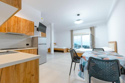 a kitchen and dining room with a table and chairs at Kotarja Apartments in Dhërmi