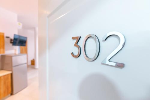 a white wall with a house number sign on it at Kotarja Apartments in Dhërmi