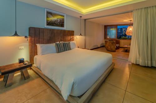 een slaapkamer met een groot bed en een tafel bij The Charlee Hotel in Medellín