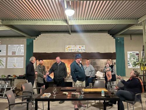 a group of people standing around a table in a room at Soebatsfontein Guest Lodge in Soebatsfontein