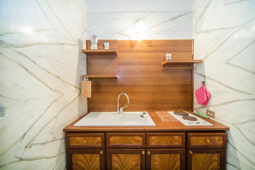 Łazienka z umywalką i marmurową ścianą w obiekcie Chiaia B&B w mieście Neapol