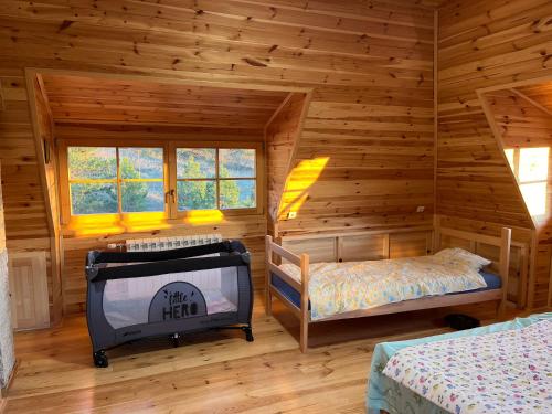 1 dormitorio con TV en una cabaña de madera en Gorske vile - Ljubav, Vera i Nada, en Kosjeric