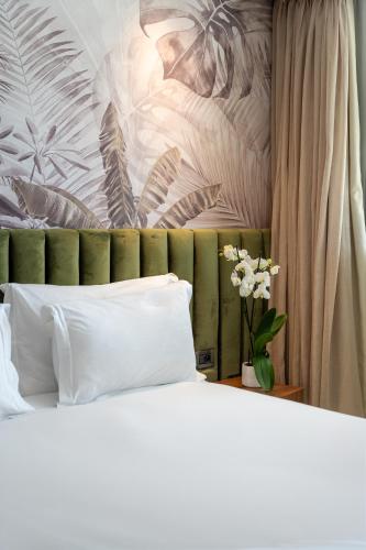 a bed with white pillows and a painting on the wall at Kenzi Solazur in Tangier