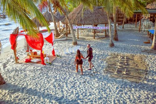 a man and a woman walking on a beach at Hotel Camino Verde in Tolú