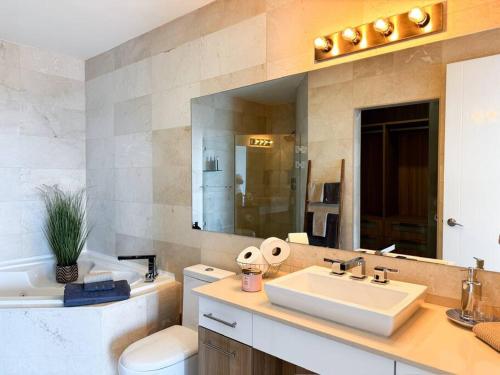 Un baño con lavabo, inodoro y espejo. en Luxury Beachfront Apartment Near Panama City, en ArraijÃ¡n