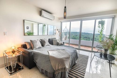 Un dormitorio con una cama y una ventana grande en Luxury Beachfront Apartment Near Panama City, en ArraijÃ¡n
