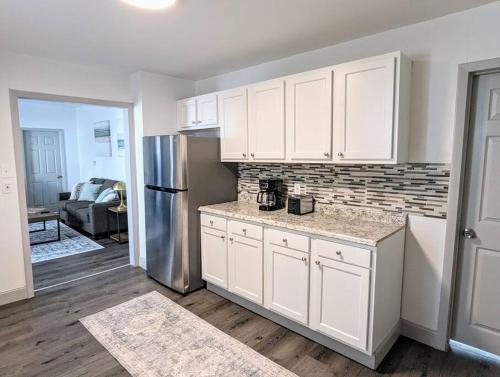 a kitchen with white cabinets and a stainless steel refrigerator at Great Value in 253 Park Place in Schenectady