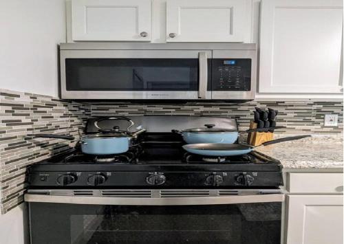 a kitchen with two pots on a stove with a microwave at Great Value in 253 Park Place in Schenectady