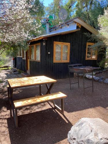a picnic table in front of a cabin at Cabañas Parque Almendro in San José de Maipo