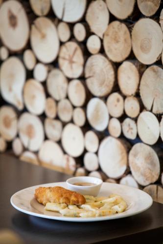 a plate with a piece of food and french fries at Przystań Leśniów in Żarki