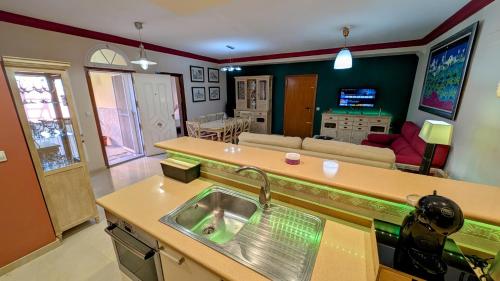 a kitchen with a sink and a living room at Viña Home in Torre del Mar