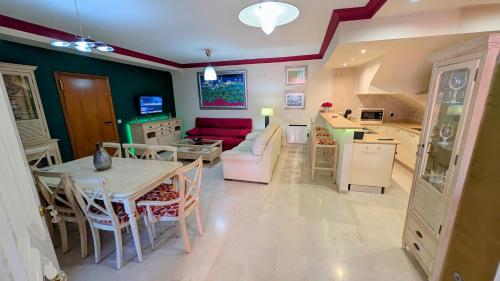 a kitchen and living room with a table and a couch at Viña Home in Torre del Mar