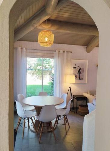 une salle à manger avec une table et des chaises et une fenêtre dans l'établissement Villa Cosy, 75m2, climatisé, 200m plage, parking, à Lecci