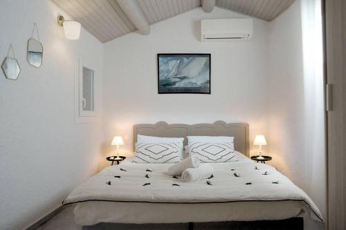 une chambre avec un grand lit blanc avec deux lampes dans l'établissement Villa Cosy, 75m2, climatisé, 200m plage, parking, à Lecci