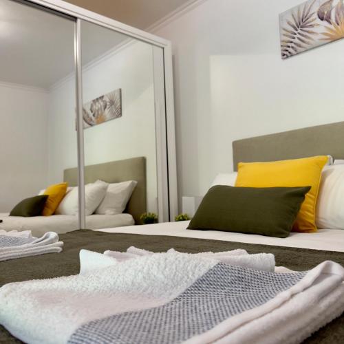 a bedroom with a mirror and a bed with a blanket at Green House in Calheta