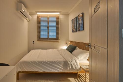 a small bedroom with a bed and a window at Banwoldang Stn 3min, 2F 4pm & 3F 8pm Check-in, Table for 6, Hotel bedding, Luggage Storage in Daegu
