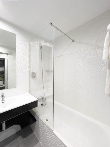 a white bathroom with a shower and a sink at Hoteles Urbanos N Avenida de España in Fuenlabrada