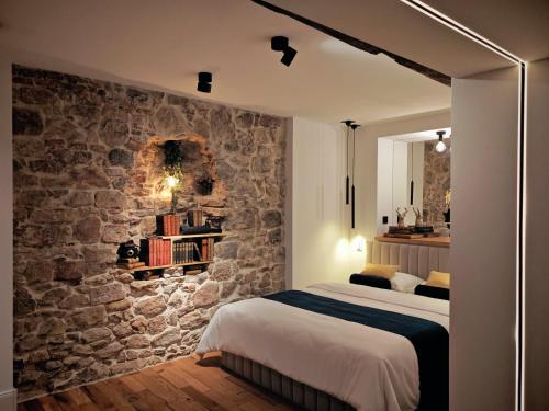 a bedroom with a stone wall and a bed at Stilvolle Suite im Herzen von Landau in Landau in der Pfalz