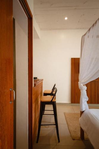 a bedroom with a chair and a desk and a bed at Villa Estrela Bungalow in Itacaré