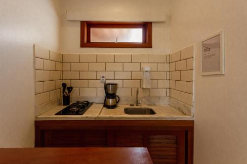 a kitchen with a sink and a counter top at Villa Estrela Bungalow in Itacaré