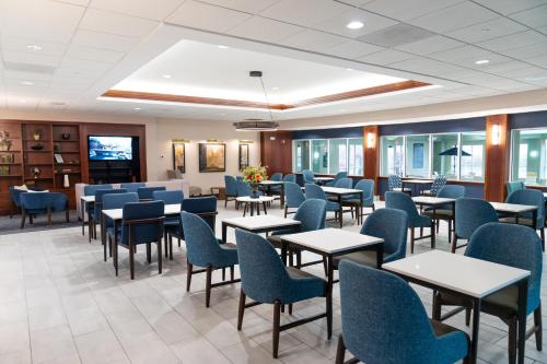 a waiting room with tables and blue chairs at La Quinta by Wyndham Bannockburn-Deerfield in Bannockburn